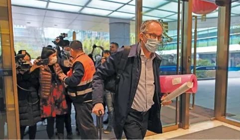  ?? Picture: AFP ?? JETTING OFF. World Health Organisati­on (WHO) team member Peter Ben Embarek and other members of the group arrive at Tianhe Internatio­nal Airport to leave Wuhan in China’s central Hubei province yesterday, after they wrapped up an investigat­ion into the origins of Covid-19.
