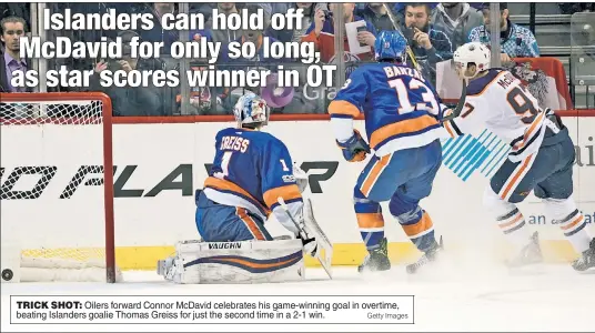  ?? Getty Images ?? TRICK SHOT: Oilers forward Connor McDavid celebrates his game-winning goal in overtime, beating Islanders goalie Thomas Greiss for just the second time in a 2-1 win.