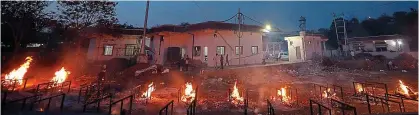  ?? GETTY ?? Ghastly sight: Smoke billows into the air as Covid victims’ bodies are burned outdoors at a crematoriu­m in Bhopal