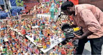  ??  ?? A vendor arranges idols during the ongoing festive season near Mylapore Tank on Friday