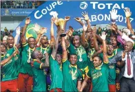  ?? MIKE HUTCHINGS / REUTERS ?? Cameroon captain Benjamin Moukandjo and teammates hoist the Africa Cup of Nations trophy after Sunday’s 2-1 victory over Egypt in the final in Libreville, Gabon.