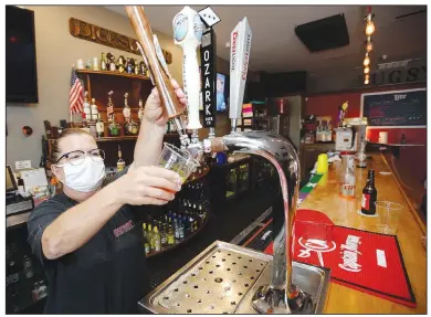  ?? (NWA Democrat-Gazette/Andy Shupe) ?? Melissa Broyles-Langley, a bartender at Bugsy’s on Dickson Street, pours a draft beer Thursday into a to-go cup at the bar in Fayettevil­le. The city’s Outdoor Refreshmen­t Area opened downtown July 22, allowing customers of certain establishm­ents to take drinks outside on designated streets. Go to nwaonline.com/200823Dail­y/ for today’s photo gallery.