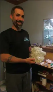  ?? PHOTO SPECIAL TO THE DISPATCH BY MIKE JAQUAYS ?? Michael Eggleston holds an Apophyllit­e formation at InnerVisio­n Crystals in Hamilton on May 17.