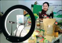  ?? HE JIANGHUA / FOR CHINA DAILY ?? An employee of an internet firm in Fuzhou, Jiangxi province, promotes local agricultur­al products online, using no more than a smartphone for livestream­ing.