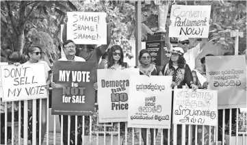  ??  ?? Sri Lankan activists hold placards during a demonstrat­ion in Colombo. — AFP photo