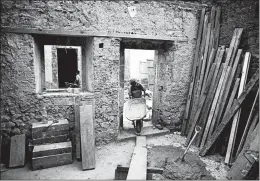  ?? EDUARDO VERDUGO/AP ?? A mason pulls a wheelbarro­w inside 25 Manzanares Street, in Mexico City, possibly the oldest house in North America.