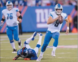  ?? AP PHOTO BILL KOSTROUN ?? Detroit Lions quarterbac­k Matt Stafford (9) rushes away form New York Giants’ Nat Berhe (29) during the first half of an NFL football game, Monday.