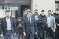  ??  ?? French centrist presidenti­al candidate Emmanuel Macron, centre, leaves his apartment in Paris