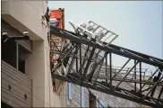  ?? SHABAN ATHUMAN / THE DALLAS MORNING NEWS ?? A crane collapsed into apartments amid severe thundersto­rms Sunday in Dallas, leaving one woman dead and injuring six others as storms pummeled parts of North Texas.