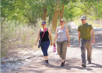  ?? ADOLPHE PIERRE-LOUIS/JOURNAL ?? From left, Stacy Yeager of Albuquerqu­e and Jennifer Franks and her brother Jason Stone, both of Edgewood, hike near Tingley Beach on Monday. Albuquerqu­e imposed fire restrictio­ns, but all city Open Space areas remain open to the public.