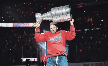  ?? NICK WASS THE ASSOCIATED PRESS ?? Capitals captain Alex Ovechkin lifts the Stanley Cup during the team’s banner-raising ceremony in Washington on Wednesday night. The Capitals showed no signs of a Stanley Cup hangover, beating the Boston Bruins 7-0.