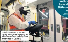  ??  ?? Staff, kitted out in full PPE, apply a long-lasting spray on Metro carriages to help keep them free of Covid-19