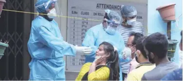  ?? Associated Press ?? ↑
A woman reacts as a health worker tries to take her swab sample in Jammu on Wednesday.