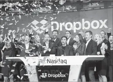  ?? Drew Angerer Getty Images ?? DROPBOX EXECUTIVES ring the opening bell at the Nasdaq MarketSite in New York as they celebrate the launch of the San Francisco file-sharing company’s initial public offering. The firm was founded in 2007.