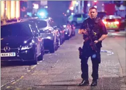  ?? Associated Press photos ?? An armed police stands on Borough High Street as police deal with an incident on London Bridge in London, Saturday.