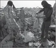  ?? AP/GHAITH ALSAYED ?? People in Barisha, Syria, go through the rubble of a destroyed house Sunday after an operation by the U.S. military that targeted Islamic State leader Abu Bakr al-Baghdadi.