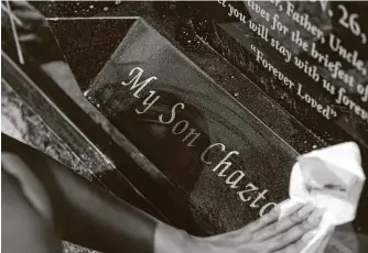  ?? Godofredo A. Vásquez / Staff photograph­er ?? Mykala Nelson wipes red dirt and dust off her brother’s tombstone while her family visits the gravesite in Freestone County, about 2½ hours northwest of Houston, in July.