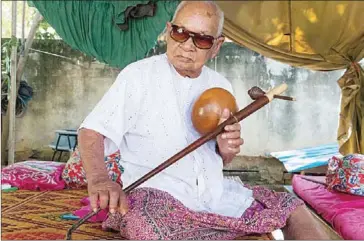  ?? ELI MEIXLER ?? Sok Duch plays a traditiona­l instrument, in Takeo province in 2014.