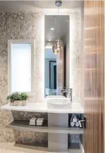  ??  ?? Julia Enriquez designed this powder room with a warm palette, intriguing textures and natural finishes, creating a sense of continuity with other spaces in the home. She placed first in Powder Room — Any Style.