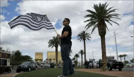  ?? JOHN LOCHER — THE ASSOCIATED PRESS ?? Matt Gutierrez carries a raiders flag along Las Vegas Boulevard Monday. NFL team owners approved the move of Raiders to Las Vegas in a vote at an NFL football annual meeting in Phoenix. the