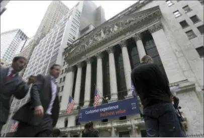  ?? RICHARD DREW — THE ASSOCIATED PRESS FILE ?? In this file photo, people pass the New York Stock Exchange. Stock markets around the world fell sharply Monday as investors turned their attention to the U.S. presidenti­al race and the first televised debate between Hillary Clinton and Donald Trump.