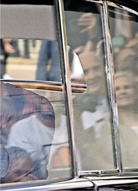  ?? ?? The King and Queen arrived in separate cars at Buckingham Palace yesterday, waving to acknowledg­e the large crowds gathered to greet them. Below right, long queues had formed at the Palace to lay floral tributes to the late Queen Elizabeth II