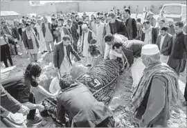  ?? Photograph­s by Marcus Yam Los Angeles Times ?? MOURNERS lay to rest Karbalai Mohammad Anwar Noori, 83. He was one of at least 50 people killed when a suicide bomber targeted Shiite worshipers in Kabul.