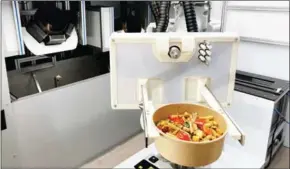  ?? AFP ?? Robotic kitchen system prepares, cooks and serves an array of hot and cold food.