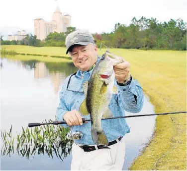  ?? STEVE WATERS/STAFF ?? Capt. Mark Benson shows the largemouth bass he caught recently at the Ritz-Carlton Golf Club Orlando Grande Lakes. “All my life I tried to sneak onto golf courses to go fishing. Now I get paid to take people fishing at the Ritz-Carlton,” he said.