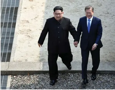  ??  ?? Kim Jong-un, left, and Moon Jae-in cross the border line together. Photo: AP