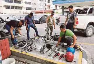  ?? [ FOTO HARUN YAHYA / BH ] ?? Anggota polis memeriksa rangka dan komponen motosikal curi yang dileraikan di sebuah rumah di Jalan Wong King Huo, Sibu, kelmarin.