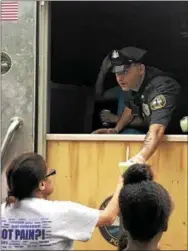  ?? GINGER RAE DUNBAR – DIGITAL FIRST MEDIA ?? Coatesvill­e Officer Matthew DiEmedio serves free Rita’s Water Ice to children who gathered at the National Night Out event.