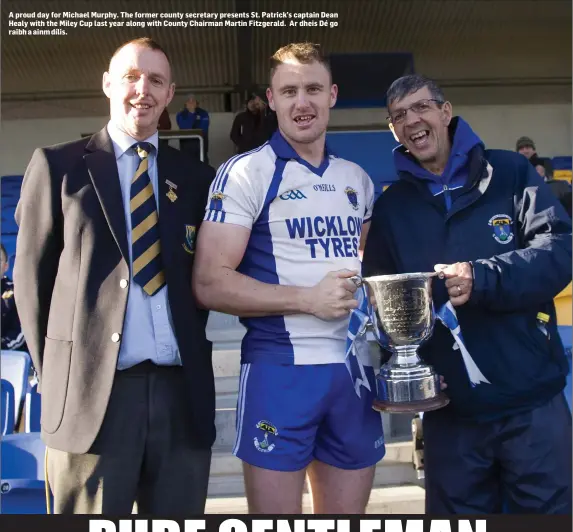  ??  ?? A pro ud day for Michael Murphy. The former county secretary presents St. Patrick’s captain Dean Healy with the Miley Cup last year along with County Chairman Martin Fitzgerald. Ar dheis Dé go raibh a ainm dílis.