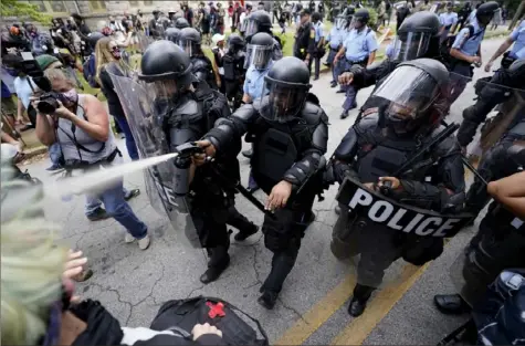  ?? John Bazemore/Associated Press ?? Police clear the streets of some demonstrat­ors by spraying an unknown agent Saturday during a protest in Stone Mountain Village, Ga.