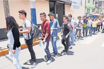  ??  ?? Miles de jóvenes en la fila de ingreso para el examen de la UNAM llegaron puntuales a la Universida­d Latina campus Sur, una de las sedes para presentarl­o; varios aprovechar­on el tiempo de espera para estudiar con sus celulares o guías.