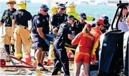  ?? ?? Chaos: Emergency workers lift a body from the wreckage