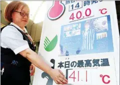  ?? JIJI PRESS/AFP ?? A department store employee replaces a sign showing a temperatur­e of 41.1 degrees Celsius in Kumagaya, in Japan’s Saitama prefecture, on Monday.