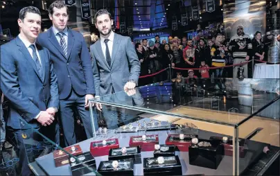  ?? CP PHOTO ?? Pittsburgh Penguins, from left, Sidney Crosby, Evgeni Malkin and Kris Letang pose for a portrait next to a display case holding the 2017 championsh­ip ring that was donated to the Hockey Hall of Fame by the Pittsburgh Penguins on Wednesday.