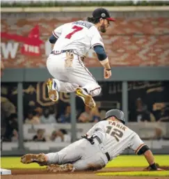  ?? THE ASSOCIATED PRESS ?? Atlanta Braves shortstop Dansby Swanson (7) watches his throw to first after forcing out the San Francisco Giants' Joe Panik during Tuesday's game in Atlanta. The Giants won 6-3, snapping their seven-game losing streak.