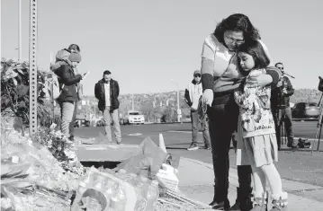  ?? GENEVA HEFFERNAN AP ?? Crystal and Ella Mondragon place flowers at a makeshift memorial near a gay nightclub in Colorado Springs, Colo., on Sunday, hours after a shooting there which killed five and wounded two dozen.