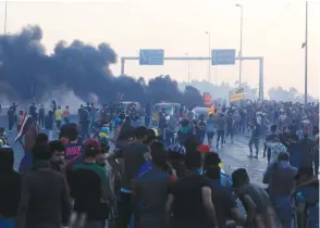  ?? (Thaier Al-Sudani/Reuters) ?? DEMONSTRAT­ORS GATHER at a protest yesterday after the lifting of the curfew, following four days of nationwide anti-government protests that turned violent, in Baghdad.