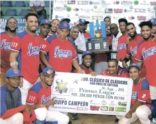  ?? FUENTE EXTERNA ?? Miguel Ceballos, presidente de la liga Emce, y Nelson Well, tesorero de la Federación Dominicana de Sóftbol, entregan el trofeo de campeón al selecciona­do Famosos de Tamboril.