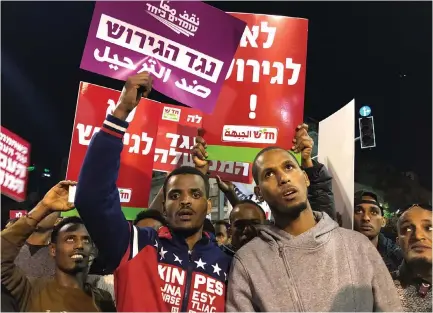  ??  ?? AFRICAN ASYLUM-SEEKERS hold signs during a protest against the Israeli government’s plan to deport part of their community.