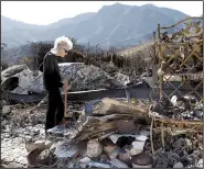  ?? AP/CHRIS PIZZELLO ?? Marsha Maus, a longtime resident of the Seminole Springs Mobile Home Park in Agoura Hills, Calif., looks through her charred belongings Sunday after wildfires destroyed her neighborho­od.