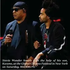  ?? REUTERS PIC ?? Stevie Wonder kneels with the help of his son, Kwame, at the Global Citizens Festival in New York on Saturday.