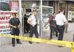  ?? ?? NYPD officers at the Bronx pharmacy where Los Angeles drill rapper Moneygang Vontae was fatally shot during theft of his gold chain on