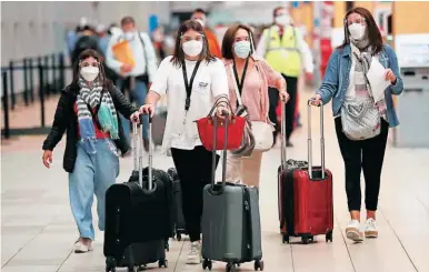  ?? ?? VIAJEROS. Varias personas se dirigen a tomar sus vuelos en el aeropuerto Tom Bradley de Los Ángeles, California.