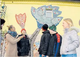  ??  ?? Die von Anna Kotik (li.) gestaltete Fassade soll die Kinder des Waisenhaus­es in Moskau erfreuen und Bürger sensibilis­ieren.