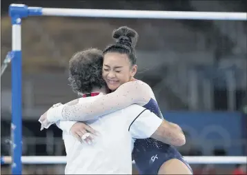  ?? GREGORY BULL — THE ASSOCIATED PRESS ?? Sunisa Lee embraces coach Jeff Graba after performing on the uneven bars during the all-around final on Thursday.