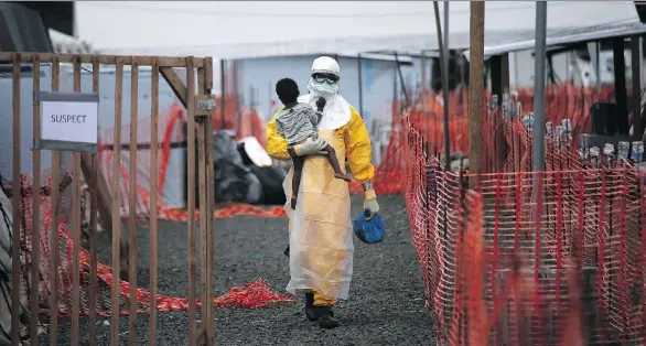  ?? PHOTOS: JOHN MOORE/GETTY IMAGES ?? A Doctors Without Borders (MSF) health worker in protective clothing carries a child suspected of having Ebola in the MSF treatment centre in 2014 in Paynesvill­e, Liberia. The girl and her mother, showing symptoms of the deadly disease, were awaiting...